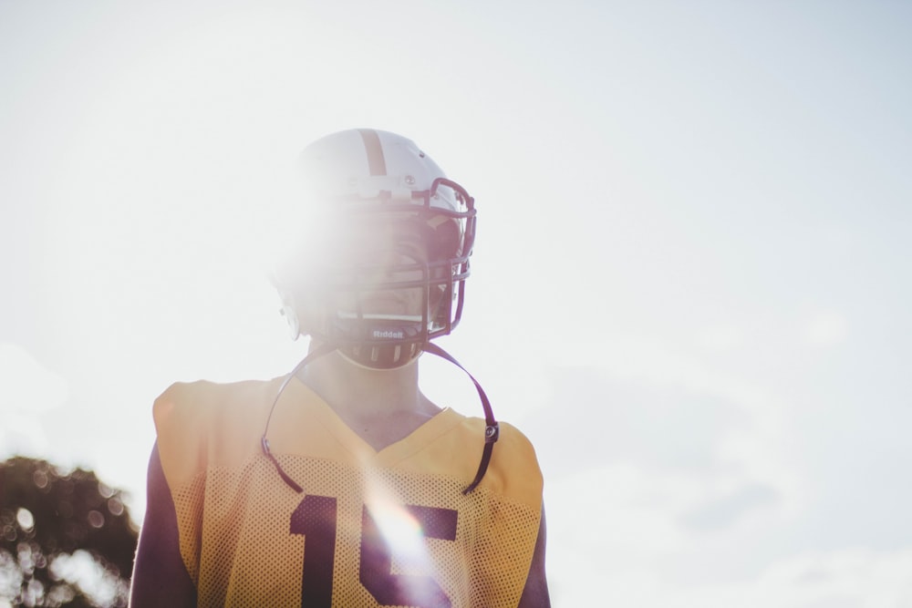 homme portant une chemise en jersey jaune et un casque blanc