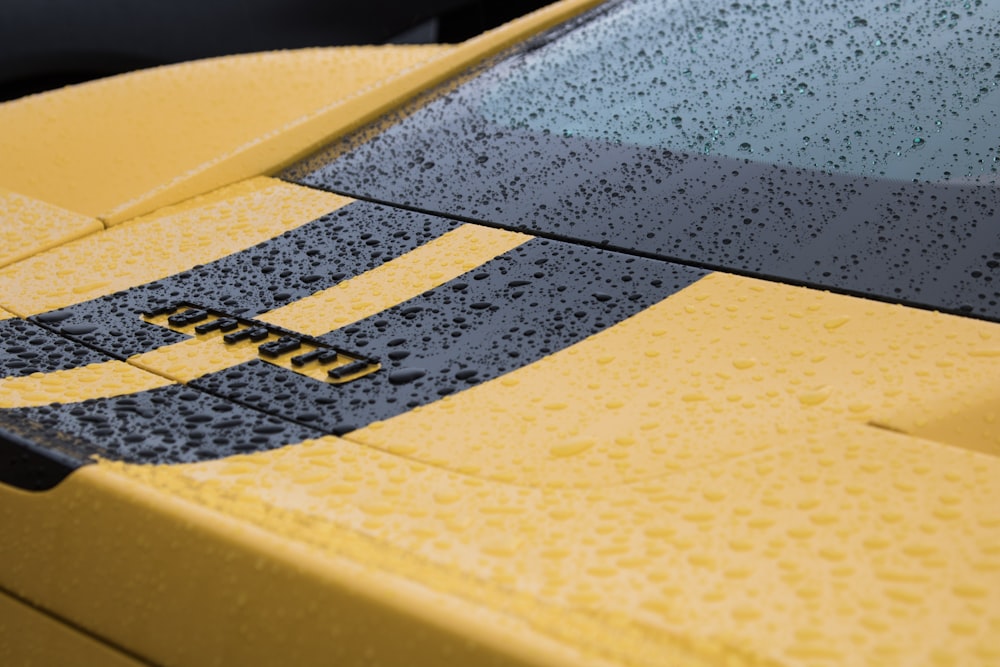 a close up of the hood of a yellow sports car
