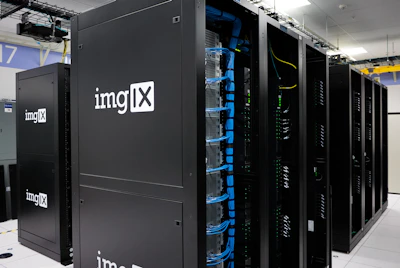 Several server racks with the logo 'imgIX' are neatly arranged in a data center. The racks are equipped with blue and yellow cable management, ensuring proper organization of the cables inside. The room is well-lit with overhead lighting and has a modern, clean appearance.