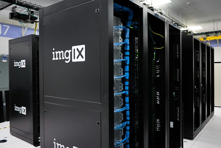 Rows of server hardware in a data center with blue indicator lights, representing distributed computing infrastructure