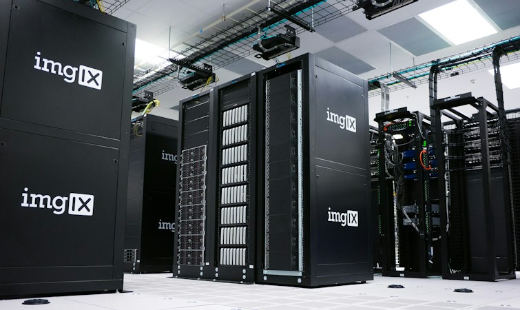 Rows of black server racks lit inside a modern data center facility, representing the computing capacity Switch is building in Southern Nevada