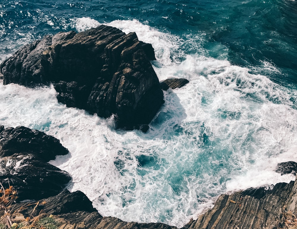 aerial view of water waves hitting on rocks