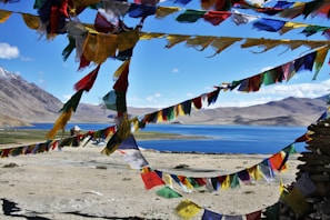 Tourists enjoying a peaceful moment at a serene temple surrounded by prayer flags.