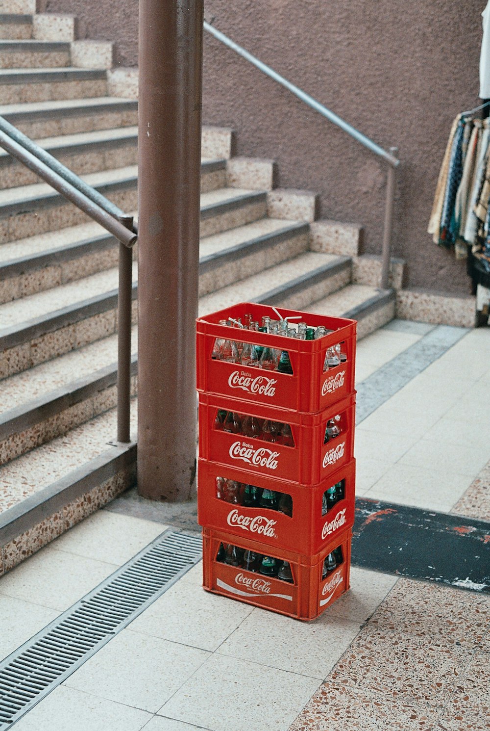Stapel von vier roten Coca-Cola-Flaschenkisten in der Nähe einer Treppe