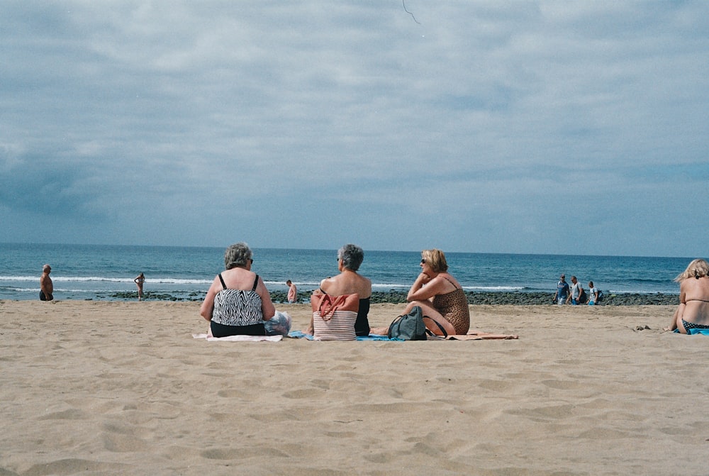 três mulheres sentadas na praia