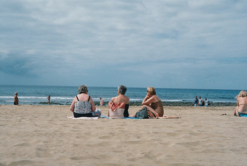 tres mujeres sentadas en la playa