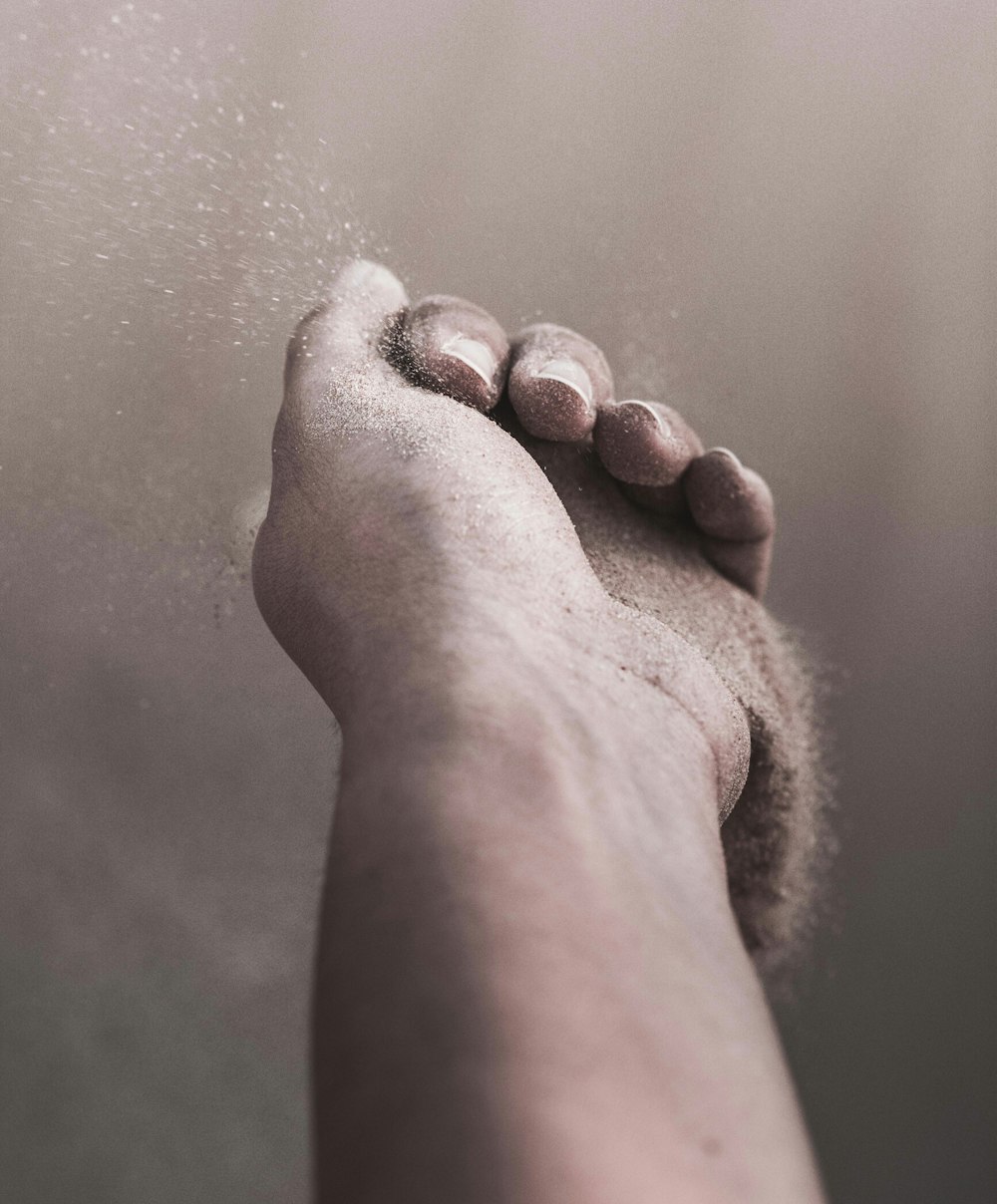 person holding brown sand close-up photography