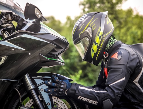 person wearing helmet while holding motorcycle