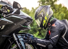 person wearing helmet while holding motorcycle