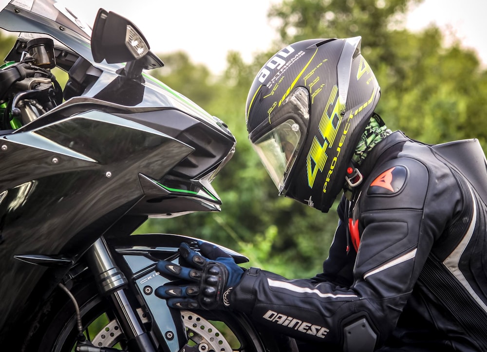 pessoa usando capacete enquanto segura a motocicleta