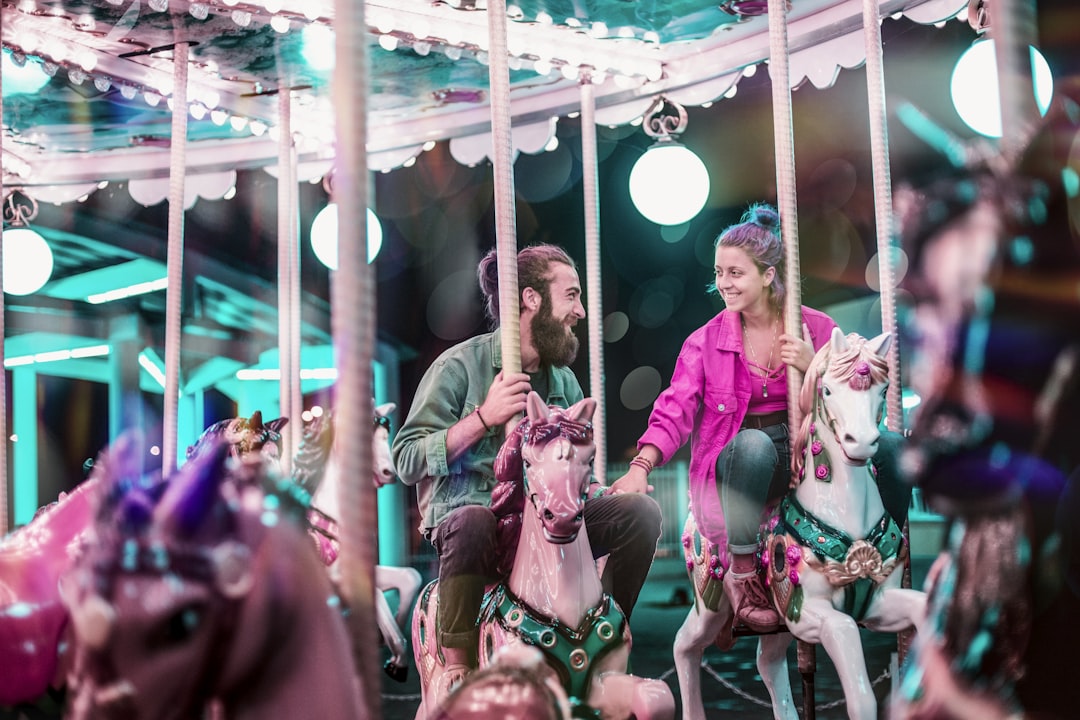 man and woman riding a carousel,