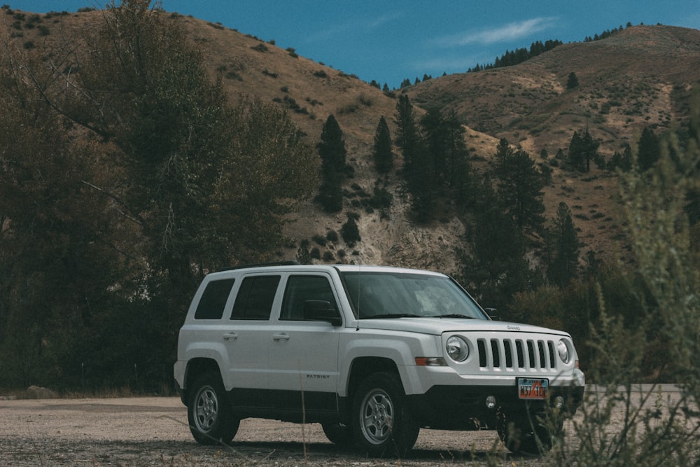 weißer Jeep-SUV tagsüber auf braunem Boden