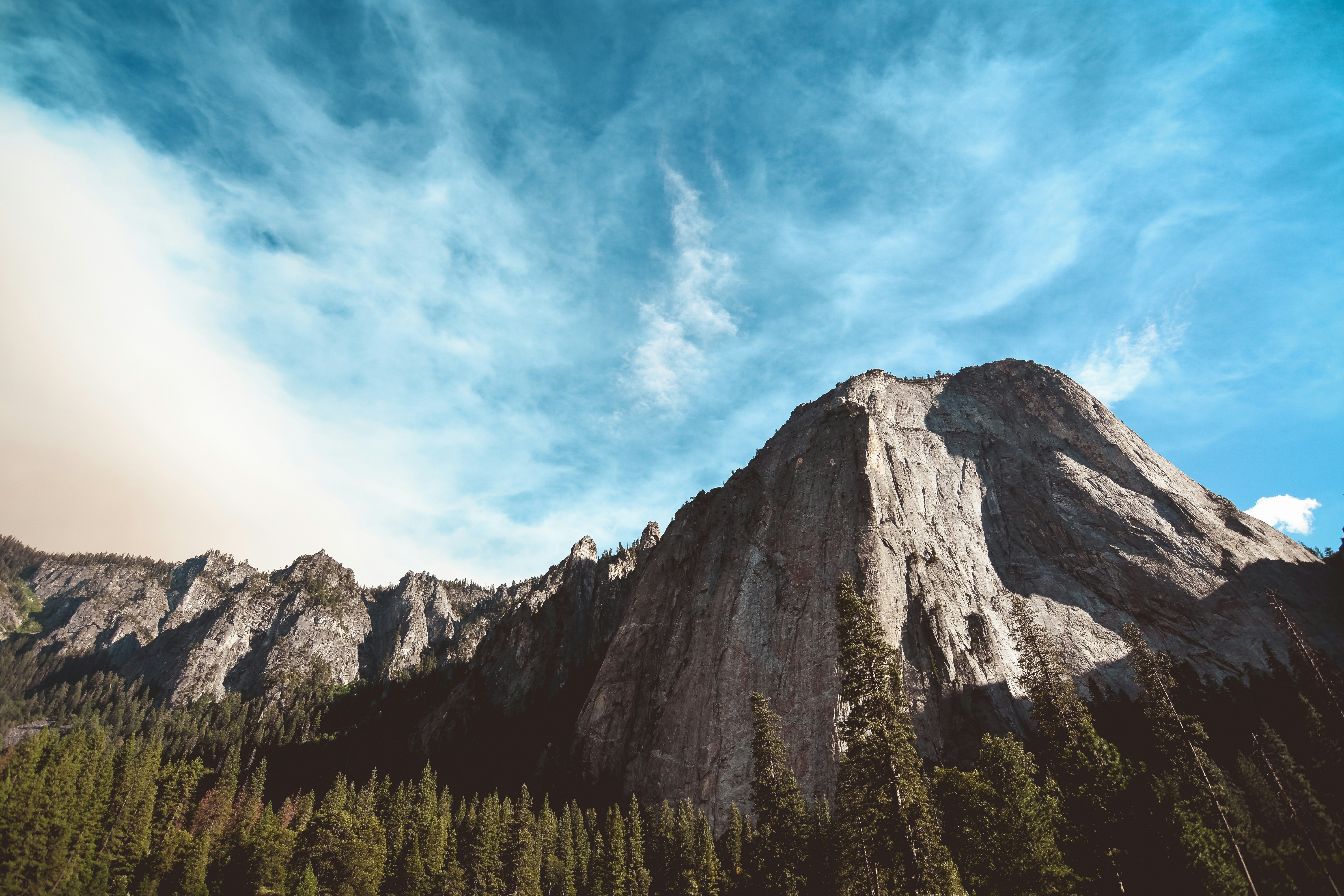 rock mountain surrounded by pine trees