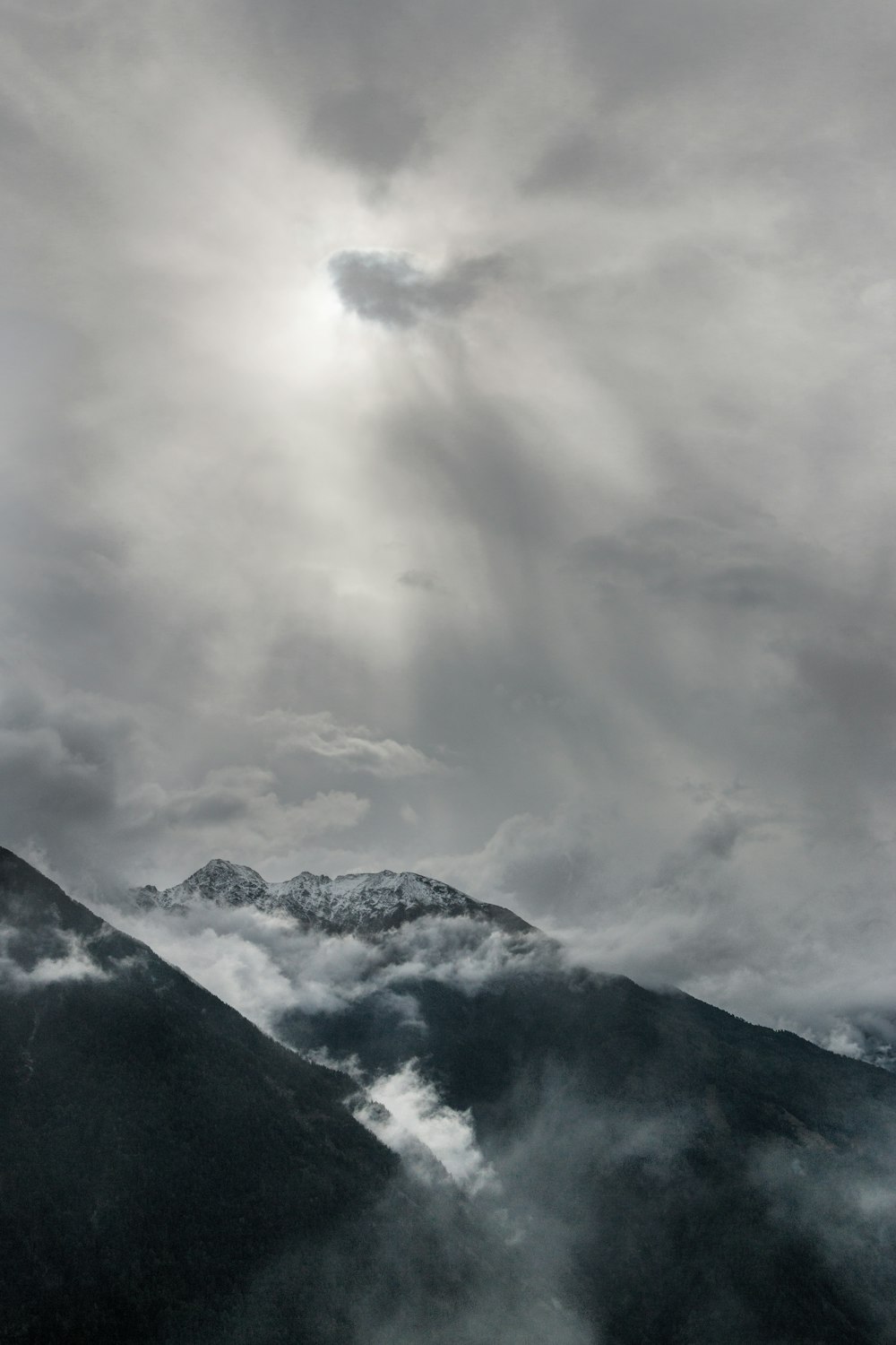 aerial view of snowy mountains under cloudy sky