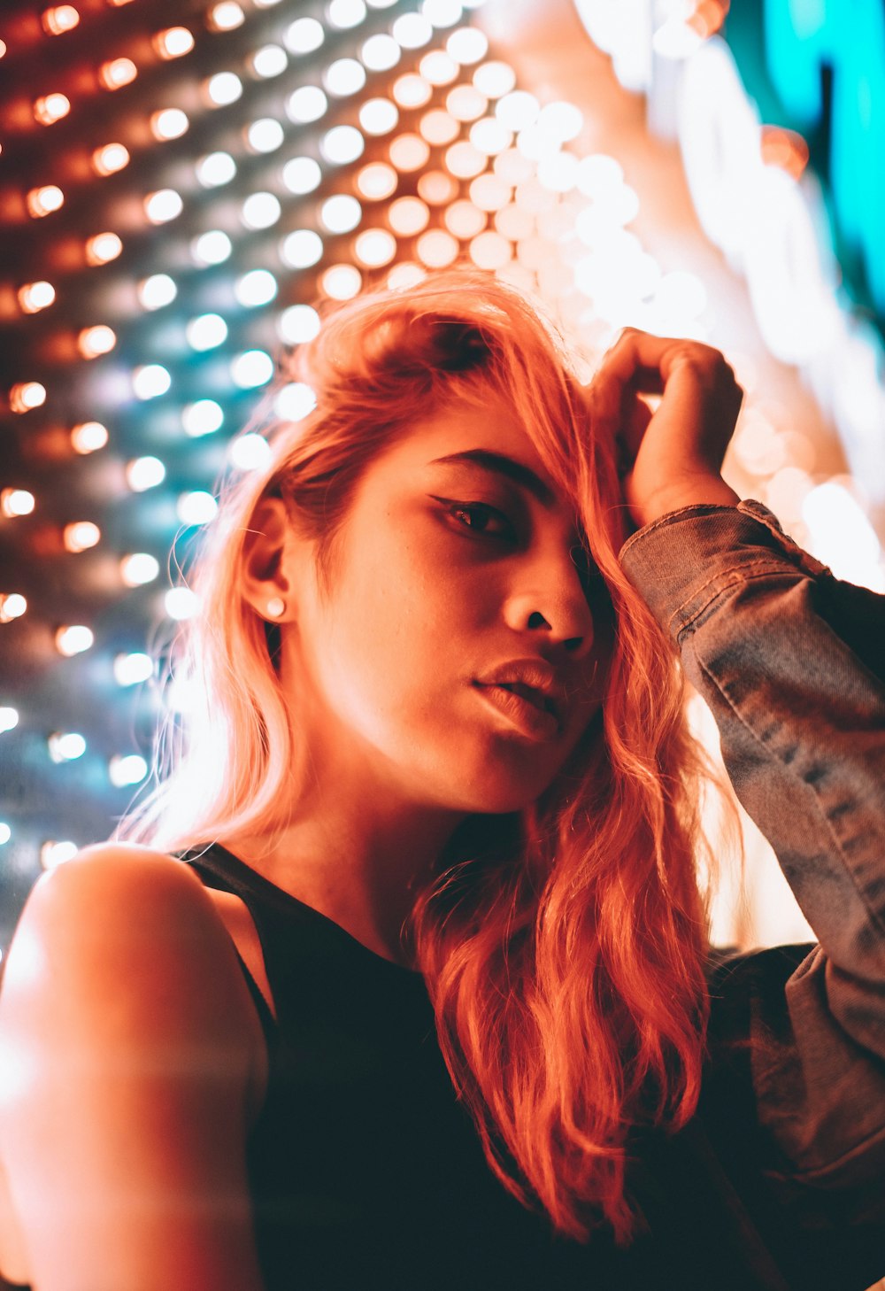 closeup photo of woman wearing black tank top and blue denim jacket