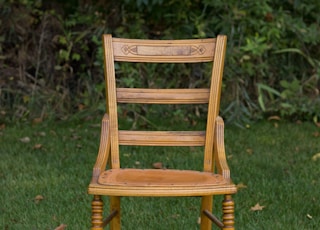 brown wooden chair on grass covered plain