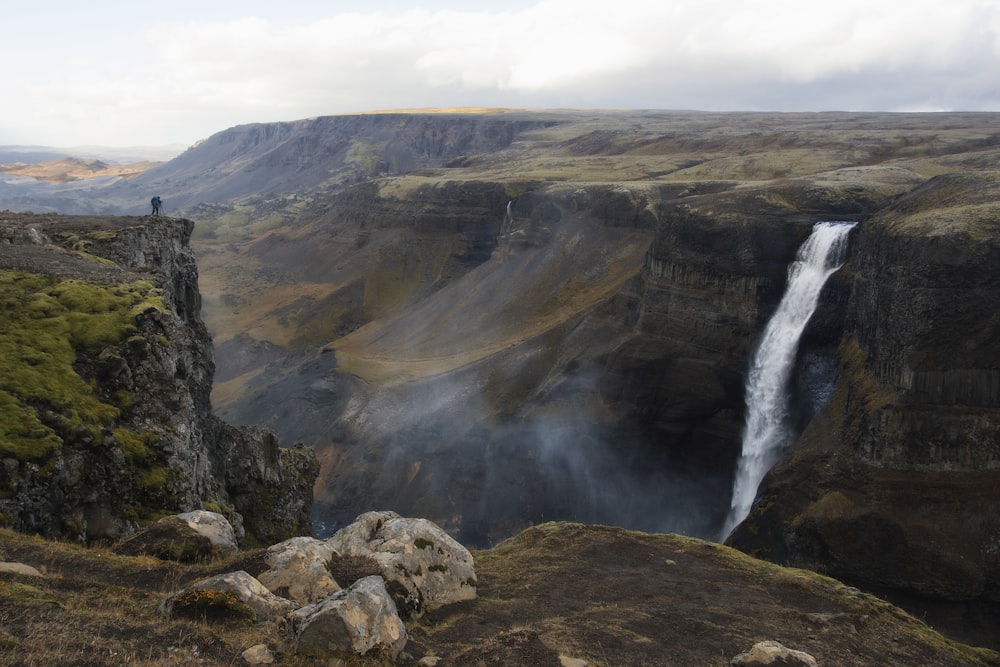 waterfalls on mountain under gray sky