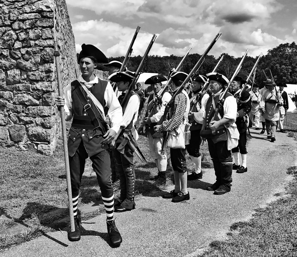 Foto en escala de grises de soldados sosteniendo rifles