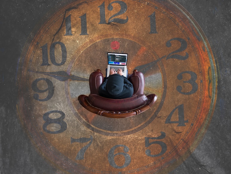 Person sits on a couch with his computer while the floor displays numbers as a watch.