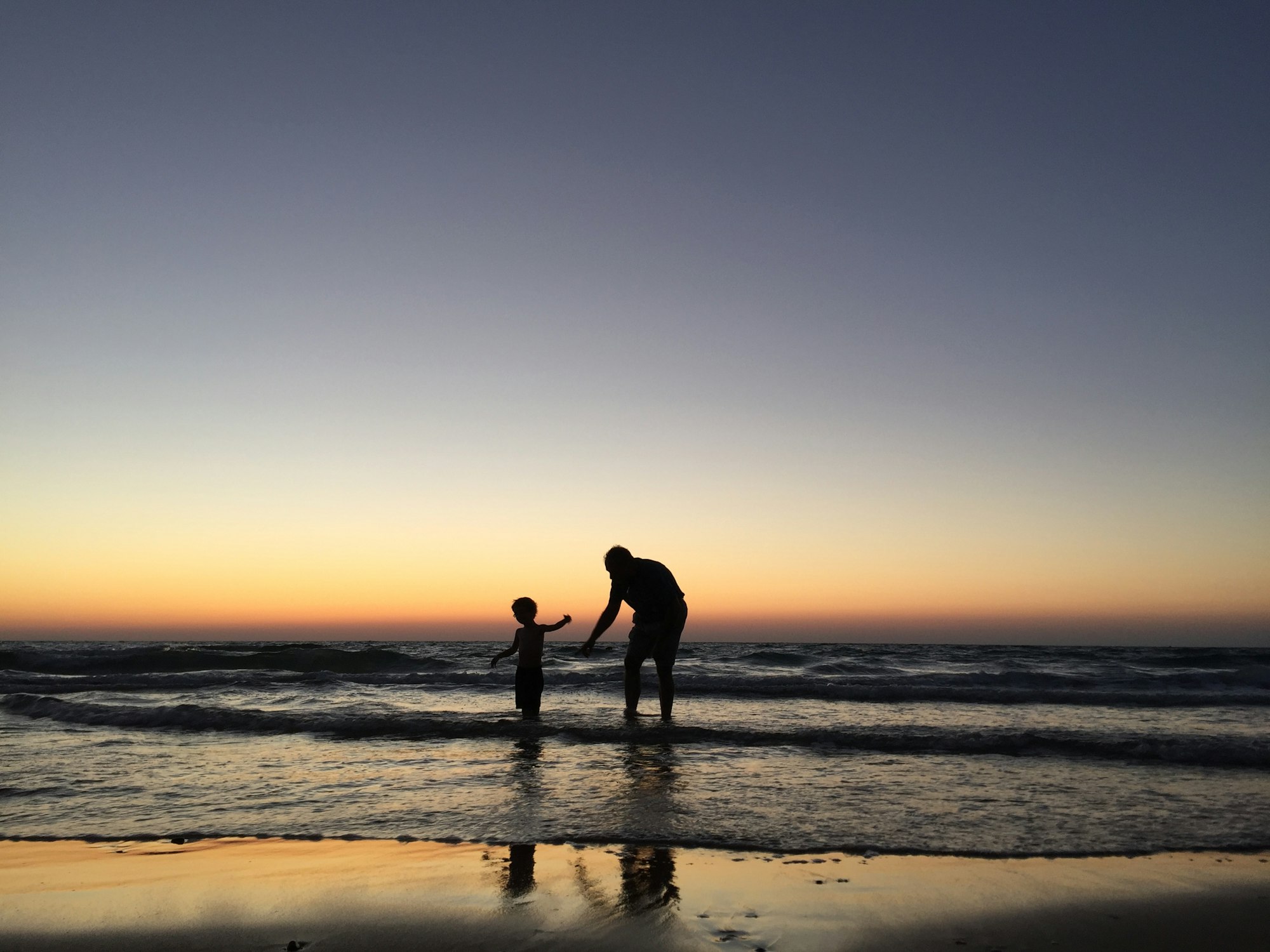 My 3-year-old was having fun in the water with his grand-daddy. It was on the seashore of Haifa in Israel (Dado beach). The sun was setting, and a magical moment appeared.