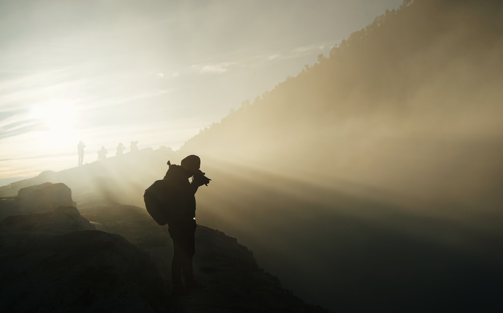 person holding camera during sunset