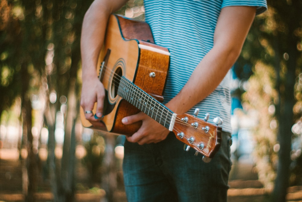 person holding acoustic guitar