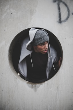 framing with frames for photo composition,how to photograph holy; man wearing black shirt and knit cap with hoodie jacket inside concrete hole