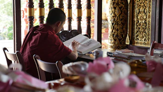 A focused student studying ancient texts with deep red and forest green accents in the background.