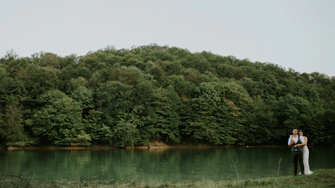 woman hugging man near body of water