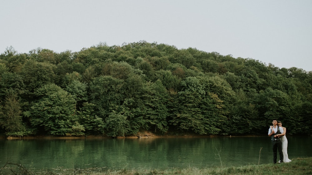 woman hugging man near body of water