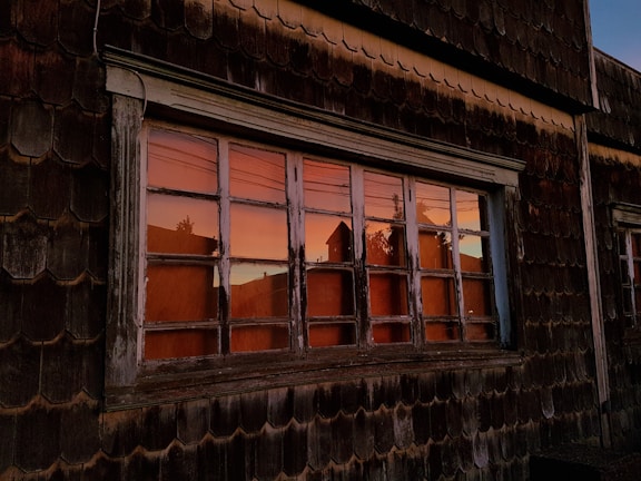 Exterior shot of the historic building housing Le Ranch, bathed in warm sunset light.