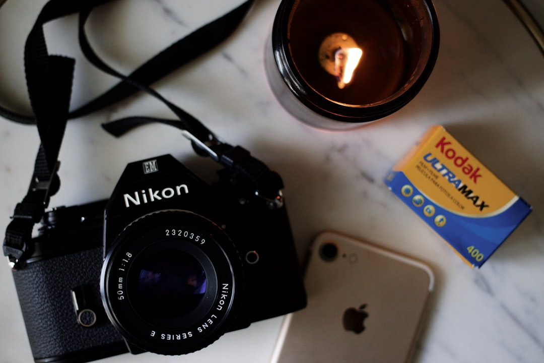 black Nikon DSLR camera on white table