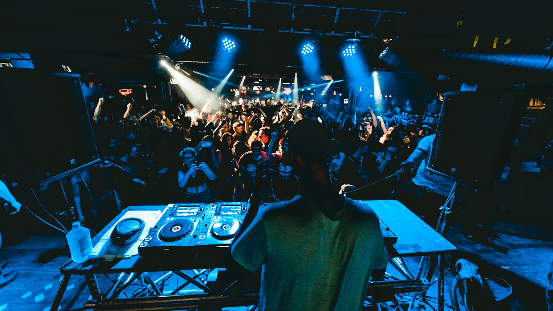 man performing DJ music with crowd during nighttime