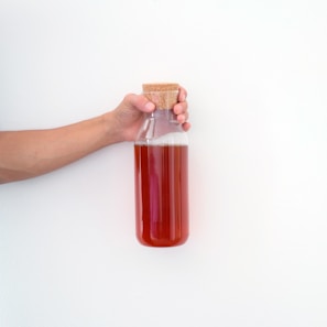 Hands holding a cork stopper next to a bottle of wine