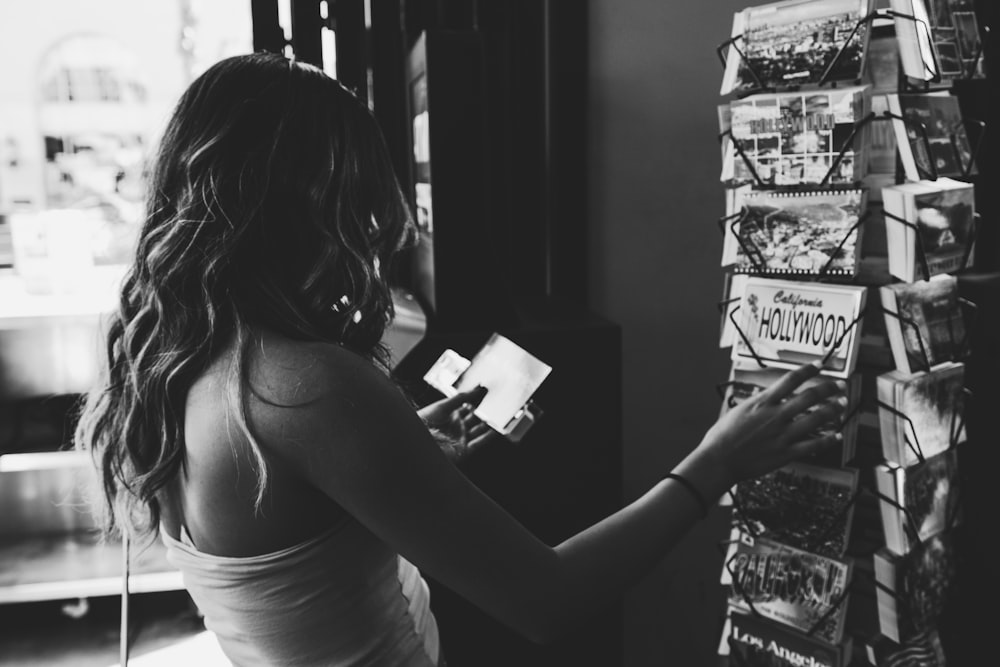 grayscale photo of woman holding magazine