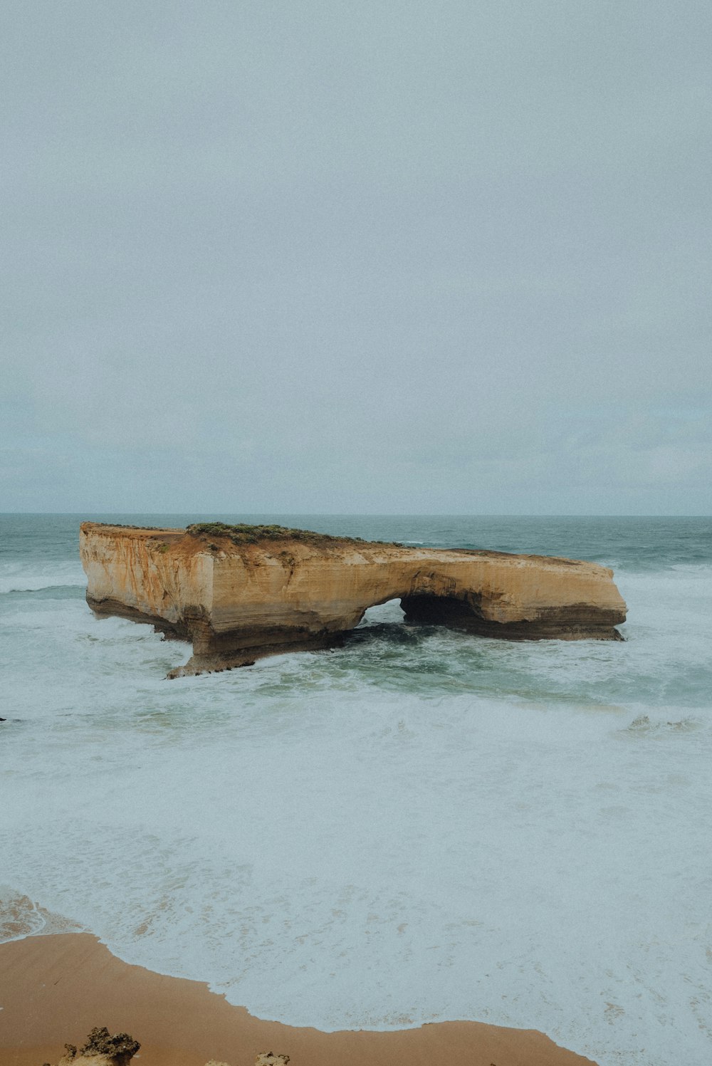 Fotografia aerea della formazione rocciosa marrone sullo specchio d'acqua