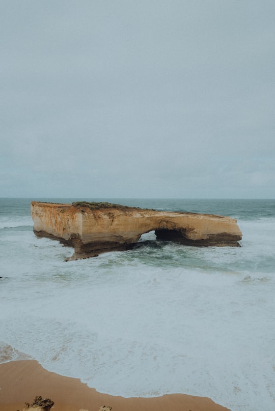 aerial view photography of brown rock formation on body of water in London Arch Australia