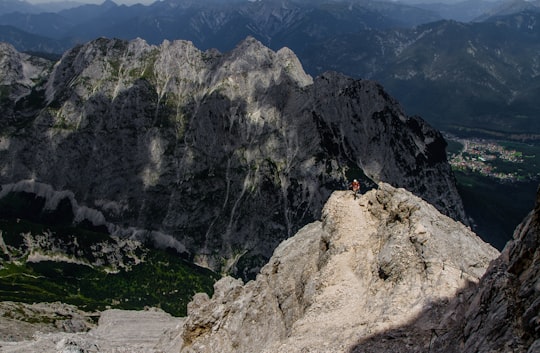 person standing in the peak of mountain range in Alpspitze Germany