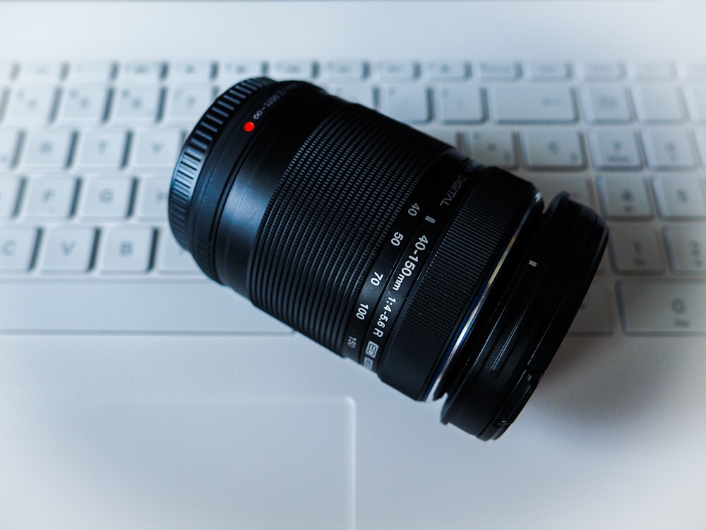 DSLR camera lens on top of Apple keyboard