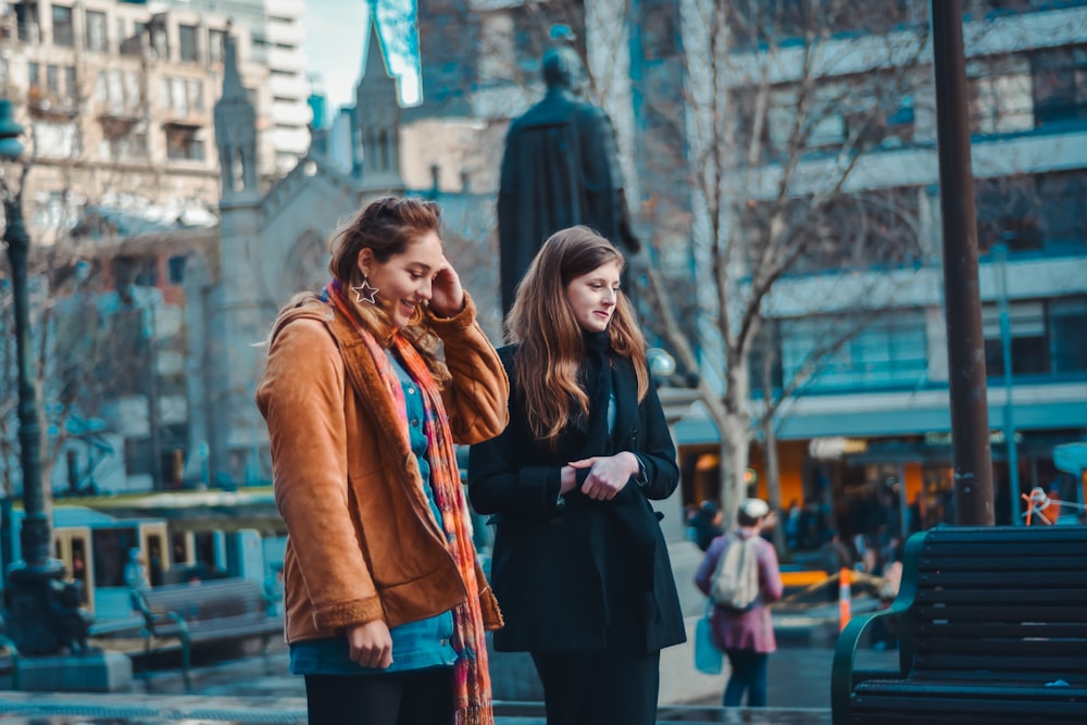 shallow focus photography of two women walking next to each other
