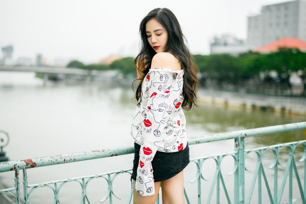 woman standing near white fence