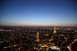 View from hotel room window overlooking a bustling cityscape at dusk.