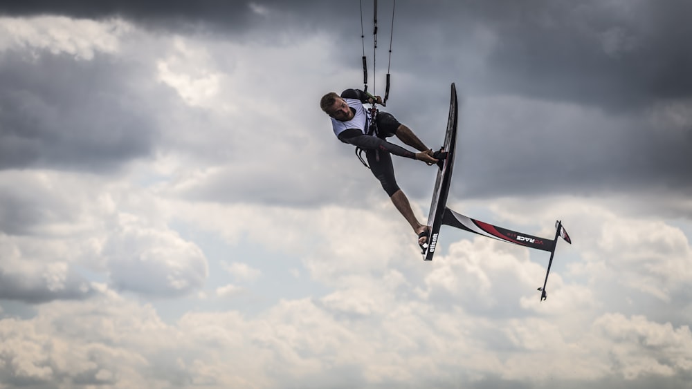 Mann macht Kitesurfer unter weißen Wolken am Tag