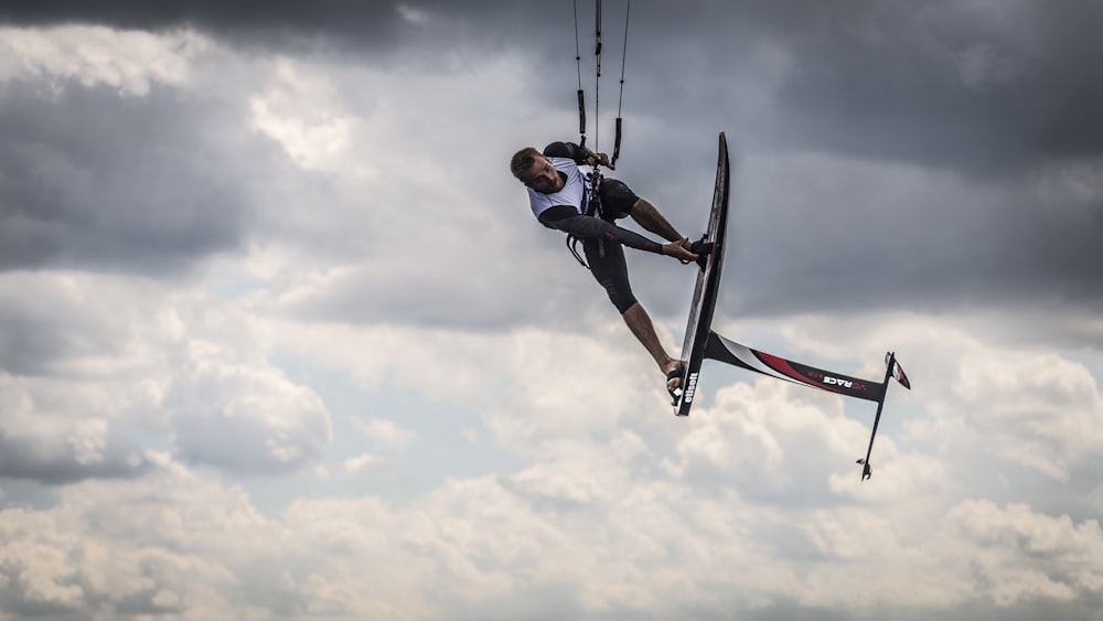 homem fazendo kitesurf sob nuvens brancas durante o dia