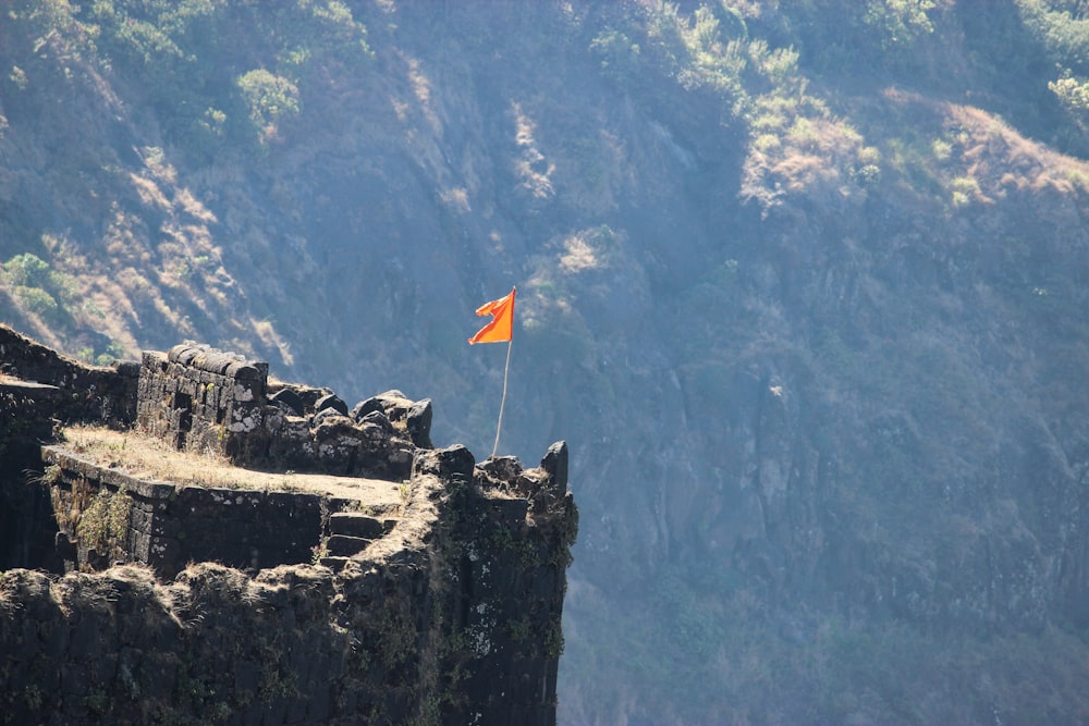 photo of flag stands on cliff