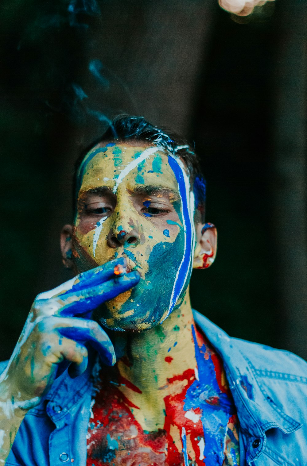 man wearing blue shirt while smoking