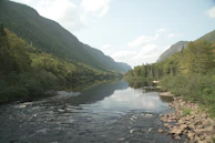 A tranquil river flowing through a vibrant, green valley.