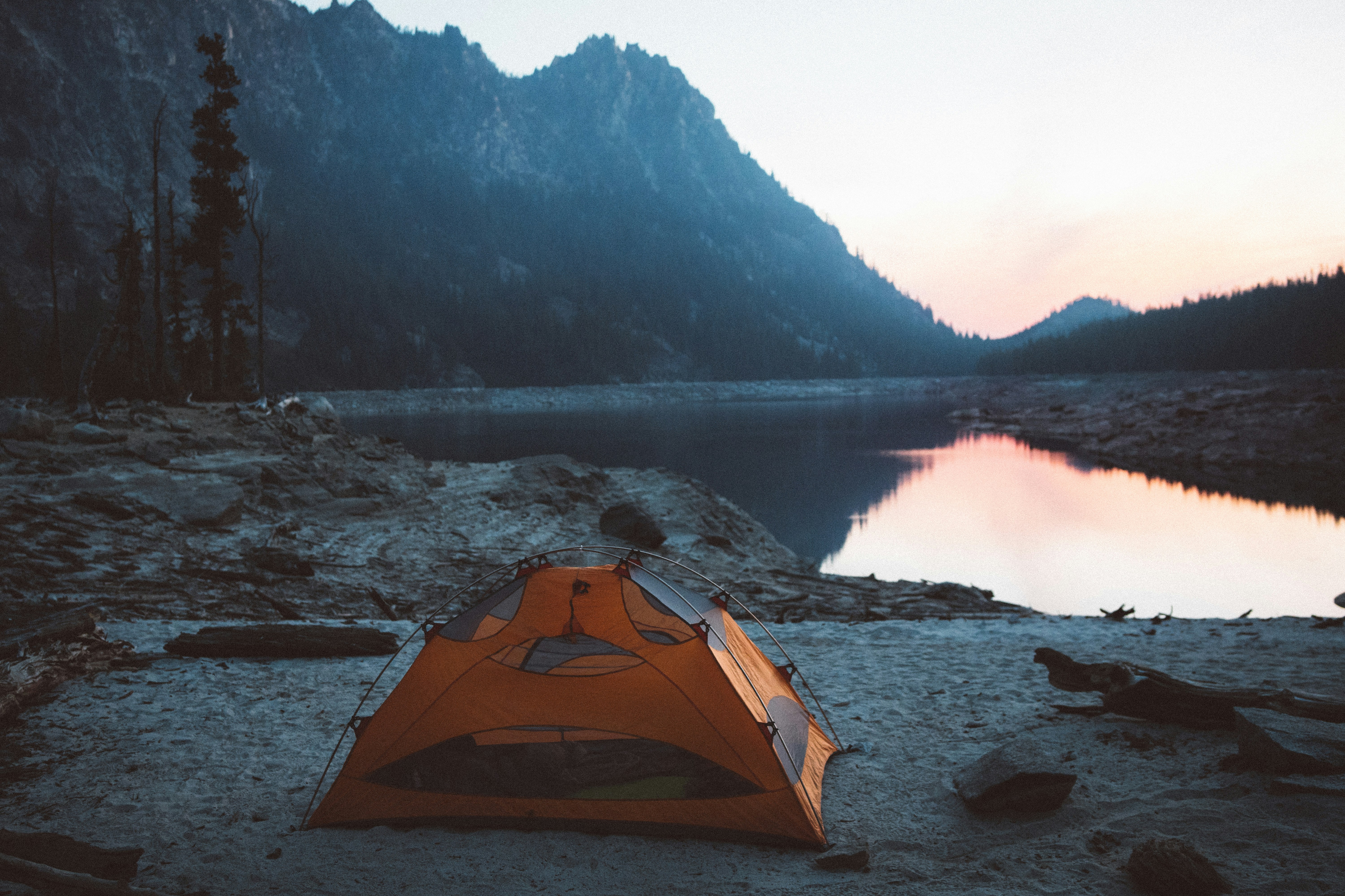 orange and gray camping tent near body of water tent teams background
