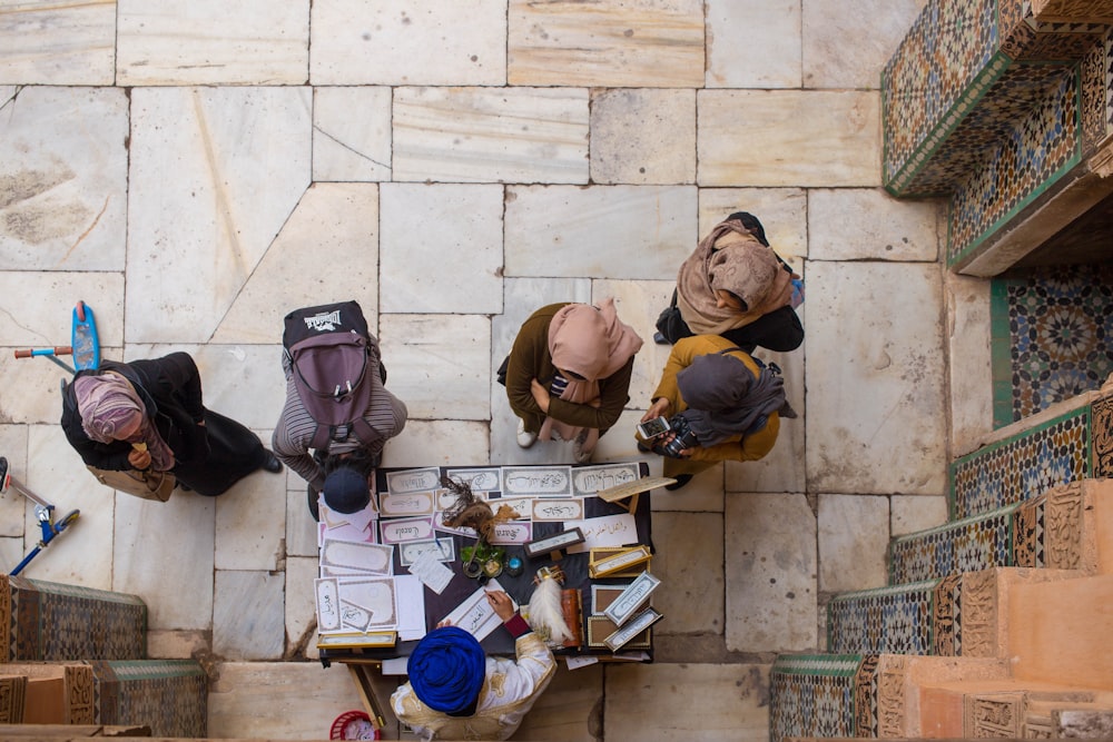 aerial view photography of people in front of man sitting next to brown wooden table