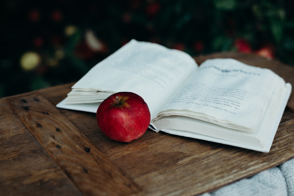 red apple beside opened book